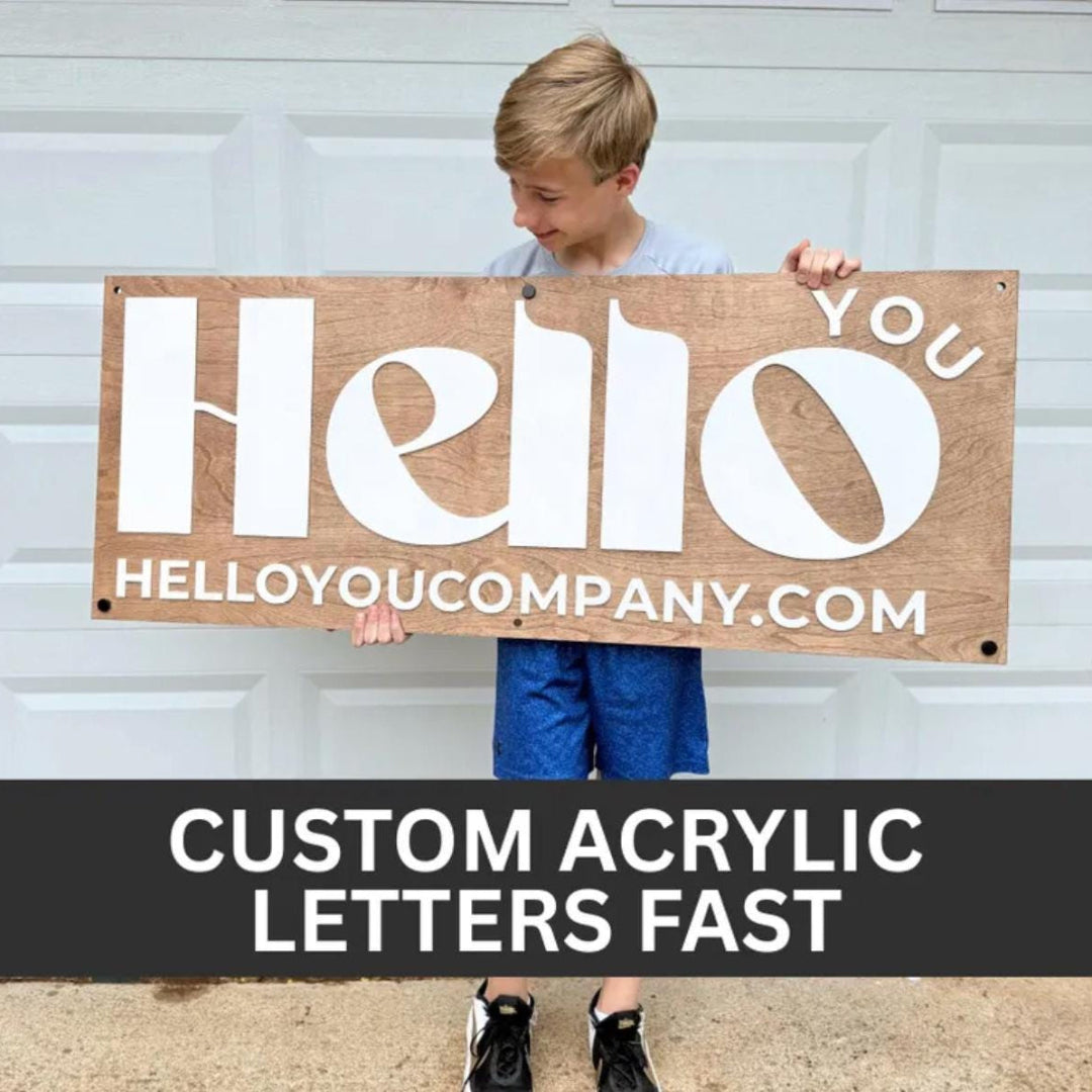 Person holding a wooden sign with 'Hello' and 'HELLOYOUCOMPANY.COM' text, standing in front of a white garage door.