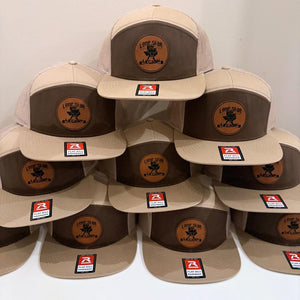 Pyramid of brown and white trucker hats with engraved logo patches
