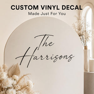 Custom vinyl decal reading The Harrisons on a white arch backdrop with florals