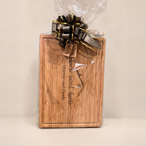 Engraved bamboo cutting board with Home Sweet Home and two names, gift wrapped with a bow and two engraved keychains