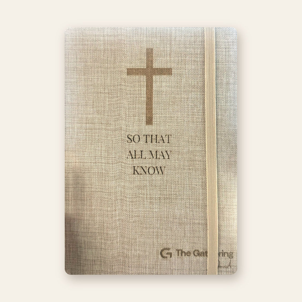 Natural linen journal with an elastic band closure and an engraved cross and logo