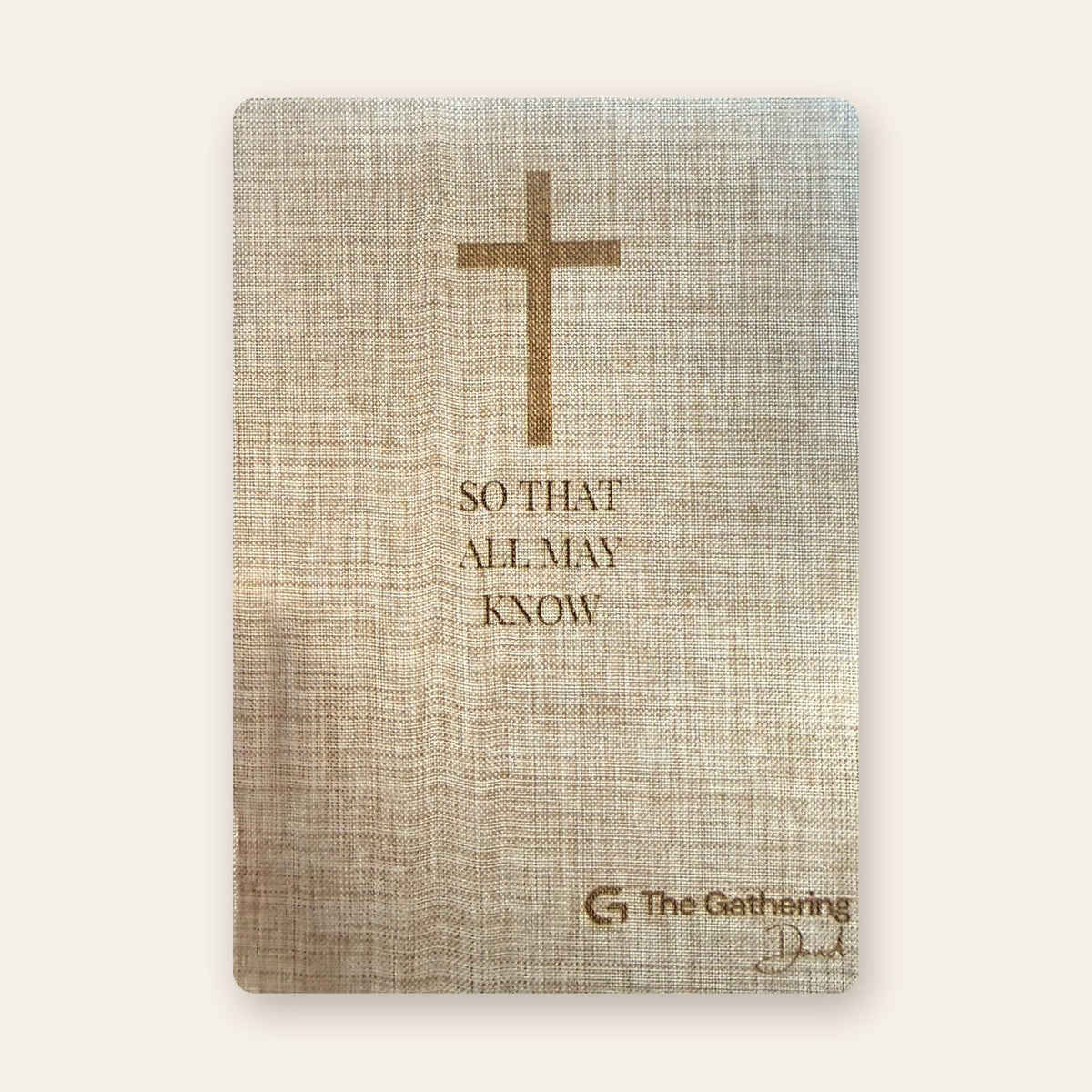 Front cover of a natural linen journal laser engraved with a cross, a verse and a church logo