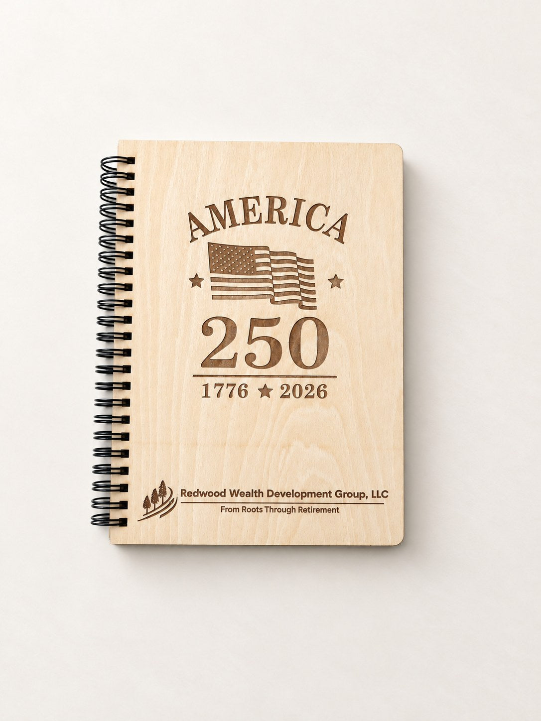 Top view of a laser engraved wood-cover spiral notebook with a black spiral and a company logo